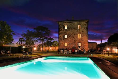 una piscina di fronte a un castello di notte di Ferienhaus für 20 Personen in Cortona, Trasimenischer See a Cortona