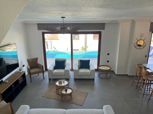 Una sala de estar con un sofá y sillas y un televisor. en Villa Deniz, en Kalkan
