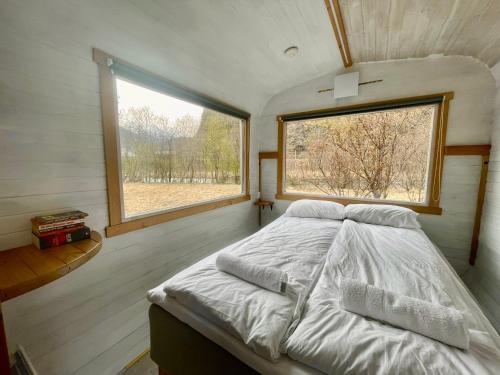 Cama en habitación pequeña con ventana en Tiny house with terrace en Flåm