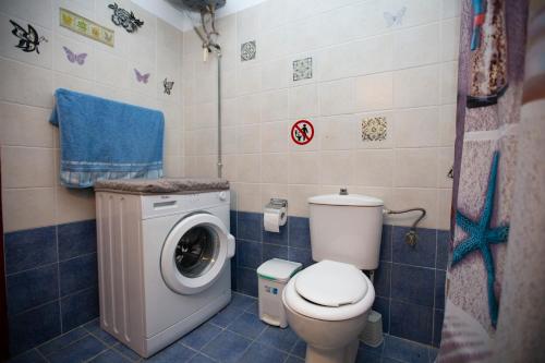 a bathroom with a toilet and a washing machine at Natural Quiet Accommodation in Kallithea Rhodes