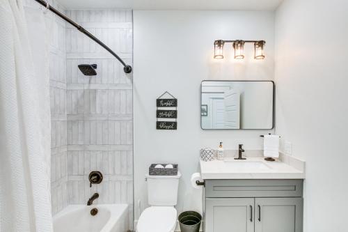 a white bathroom with a sink and a shower at Modern and Spacious Garden City Home with Pool Access! in Garden City