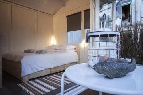 a bedroom with a bed and a table and a table sidx sidx sidx at Tiny House Madame Jeanette nabij centrum en zee in Zandvoort