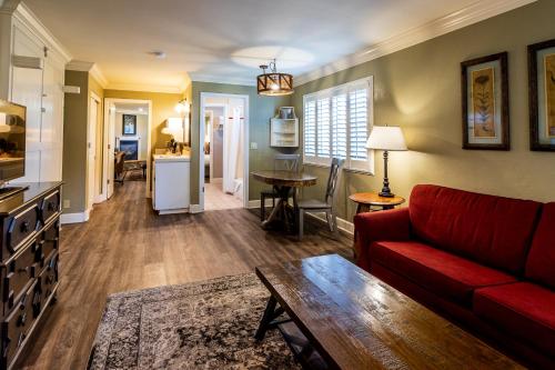 a living room with a red couch and a table at Cambria Pines Lodge in Cambria