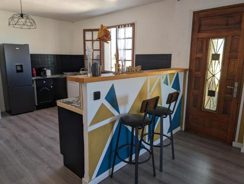 une cuisine avec un comptoir et des tabourets. dans l'établissement I Tre Taglincchi, U Sicondu - Proche mer, Clim, Wifi, Parking gratuit, à Taglio-Isolaccio