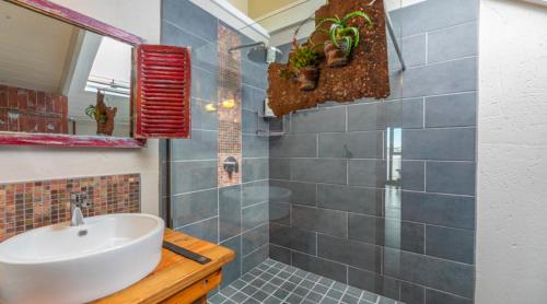 y baño con lavabo y ducha con plantas. en L'abri en Langebaan