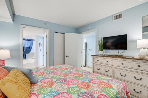 a bedroom with a bed with a tv and a dresser at Steps to Boardwalk Condo with Pool in Myrtle Beach in Myrtle Beach