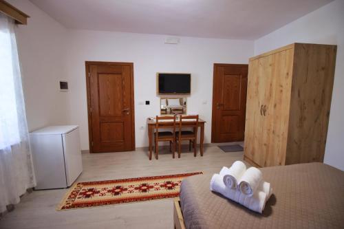 a bedroom with a bed and a desk with a television at Emblematic House Apartment 4 in Gjirokastër