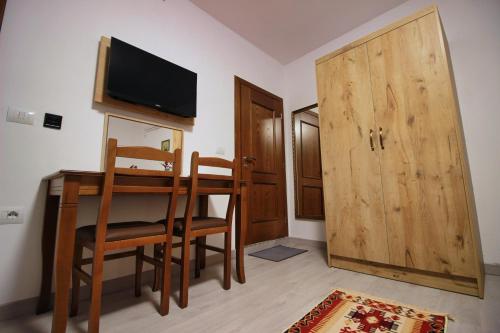 a dining room with a table and a television and a door at Emblematic House Apartment 4 in Gjirokastër