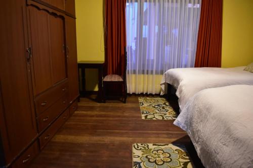 a bedroom with two beds and a dresser and a window at Raven La Paz in La Paz