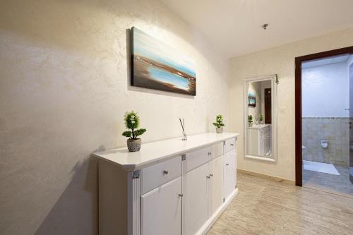 a bathroom with a white cabinet with a sink at Stylish and Sleek: Modern Well-Furnished One Bedroom Hall and Kitchen Apartment in Dubai