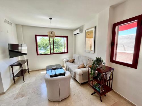 een woonkamer met een bank en een tafel bij Casares dream penthouse in Bahia de Casares