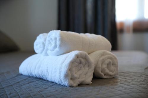 a pile of towels sitting on top of a bed at Emblematic House Apartment 4 in Gjirokastër