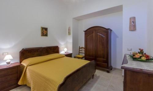 ein Schlafzimmer mit einem gelben Bett und einem Holzschrank in der Unterkunft Wohnung in Martina Franca mit Möblierter Terrasse in Martina Franca