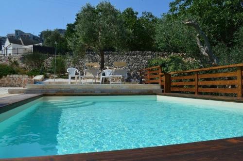 a swimming pool in a backyard with a fence at Wohnung in Martina Franca mit Möblierter Terrasse in Martina Franca