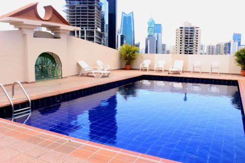 a swimming pool on the roof of a building with chairs at Hotel Terranova in Panama City