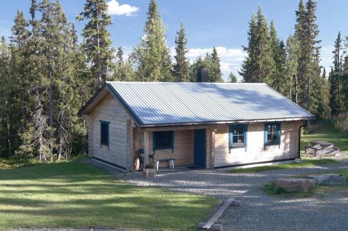 a small cabin in the middle of a yard at Charmantes modernes Blockhaus mit Kamin in Galåbodarna