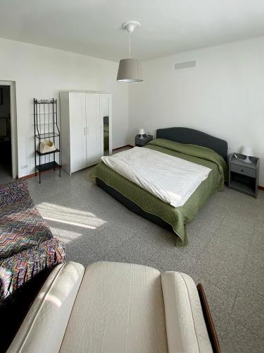 een slaapkamer met een bed en een bank erin bij Casa Serena in Induno Olona