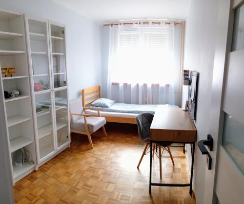 sypialnia z łóżkiem, biurkiem i oknem w obiekcie Apartament Widok w Świebodzinie