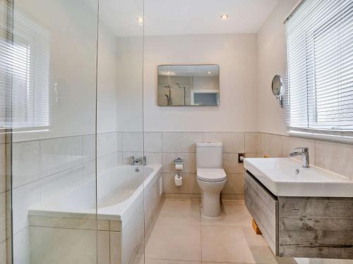 a bathroom with a tub and a toilet and a sink at 2 Bed in Gower 91723 
