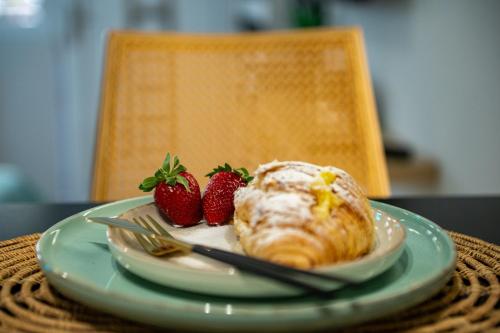 a plate with a pastry and strawberries on a table at Pocket House - Κοζανη in Kozani
