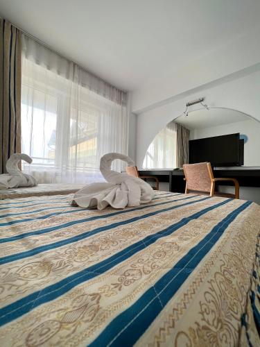 a hotel room with a bed with towels on it at Edmond in Eforie Sud