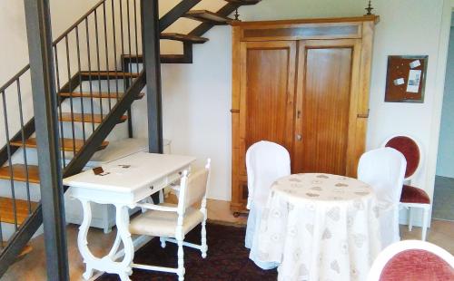 une salle à manger avec une table, des chaises et un escalier dans l'établissement La Maison di Bologna, à Bologne