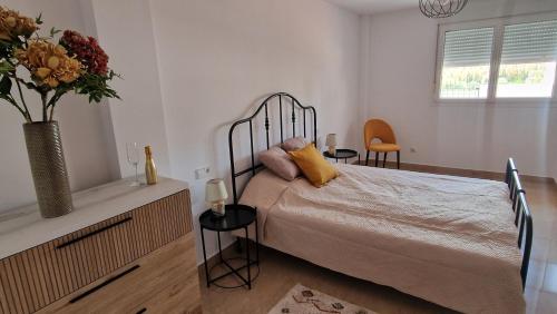 a bedroom with a bed with a vase of flowers on it at Le Casa del Sol de Marta in Manilva