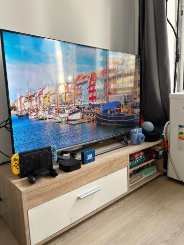 - une télévision à écran plat installée au-dessus d'un centre de divertissement dans l'établissement Appartement de charme pour les JO 2024, à Paris