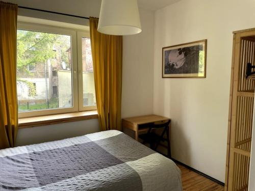 un dormitorio con una cama y una ventana en Pod Modrzewiem, en Sokołowsko