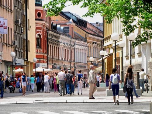 a group of people walking down a busy city street at Hostel Room in Banja Luka
