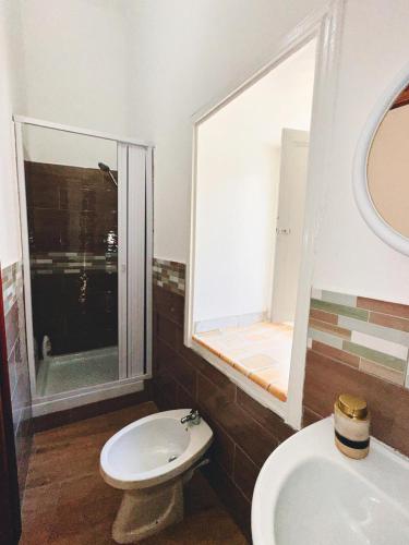 a bathroom with a toilet and a sink and a window at Monteleone rooms in Palermo