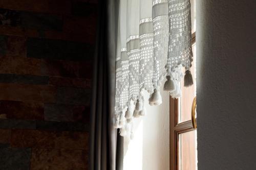 a window with a chandelier hanging from a curtain at Hotel Pashai in Gjirokastër
