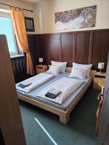 a bedroom with a large bed with a wooden headboard at Penzion Angelika in Bratislava