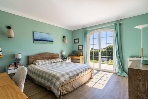 ein Schlafzimmer mit einem Bett und einem großen Fenster in der Unterkunft Charming provençal family house with swimming pool in Antibes