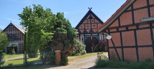 ein altes Backsteingebäude mit einem Tor und einem Zaun in der Unterkunft Ganze Wohnung in Jameln mit Garten, Grill und Terrasse - b57780 in Jameln