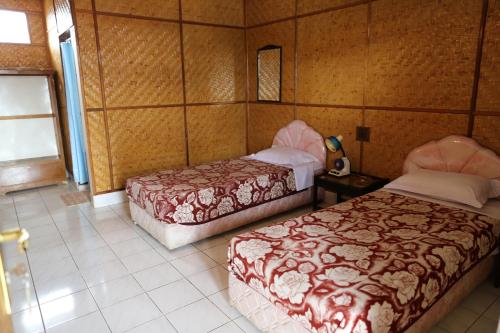 a room with two beds and a window in it at Monton Guest House in Rantepao