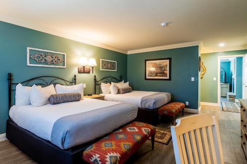 two beds in a room with green walls at Cambria Pines Lodge in Cambria
