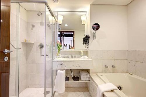 y baño con ducha, bañera y lavamanos. en GetaFlat 404 George Itaim Bibi, en São Paulo