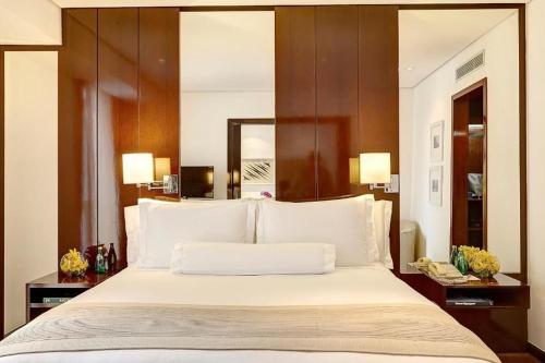 1 dormitorio con 1 cama grande con almohadas blancas en GetaFlat 404 George Itaim Bibi, en São Paulo