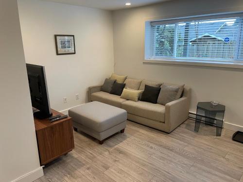 a living room with a couch and a tv at Large 2 bedroom private suite ! in North Vancouver