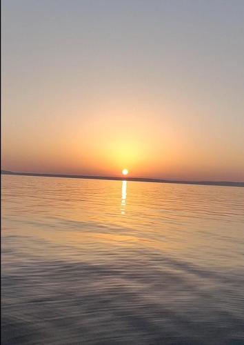 a sunset over a large body of water at nautic world studio in Tisno