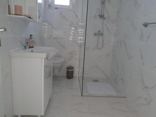 a white bathroom with a shower and a sink at Villa Sunny Day Sendi Deluxe Novalja in Novalja
