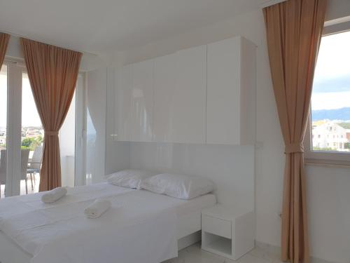 a white bedroom with a bed and a large window at Villa Sunny Day Sendi Deluxe Novalja in Novalja
