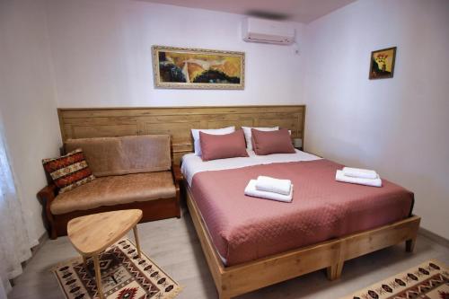 a small bedroom with a bed and a chair at Emblematic House Apartment 4 in Gjirokastër