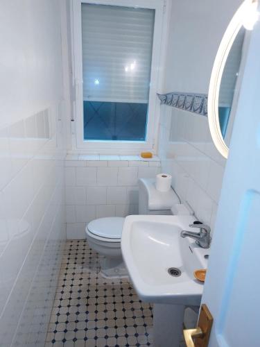 a white bathroom with a sink and a toilet at Casa Ereño in Medina de Pomar