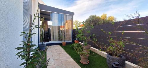 a garden with potted plants on the side of a building at Apartman Barry in Primošten