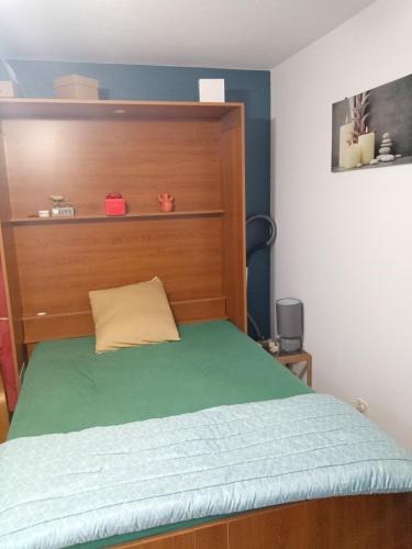 - un lit avec une tête de lit en bois dans l'établissement Studio rénové vue montagne, à Amélie-les-Bains-Palalda