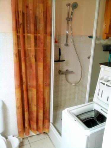 une douche avec un rideau de douche dans une salle de bain dans l'établissement Studio Petite Provence vacances ou cure vue montagne, à Amélie-les-Bains-Palalda