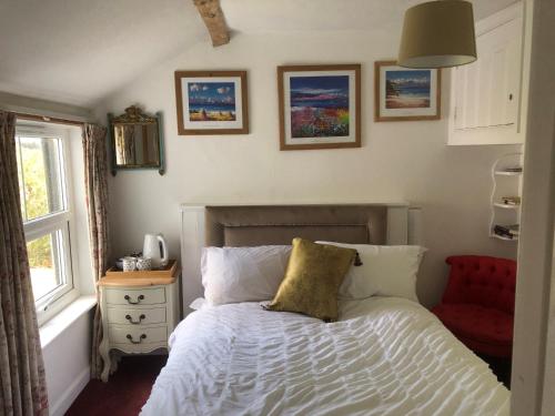 1 dormitorio con cama y ventana en Komorebi Healing House, en Dawlish