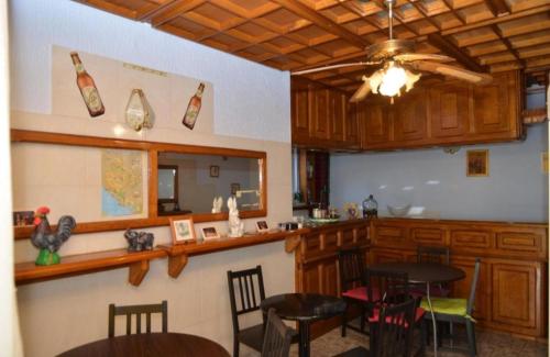 una cocina con armarios de madera, mesa y sillas en Seosko domaćinstvo STAREVINA, en Nikšić